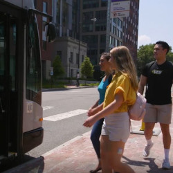 3 students about to board a GRTC bus out front of Gladding Residence Center